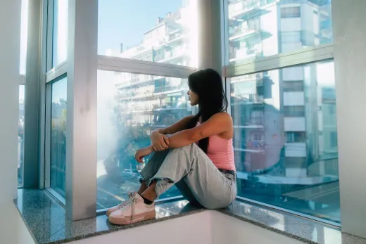 Young woman in a pink top sitting by a large - Marriage & Relationships