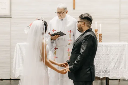Newlyweds hold hands during a church ceremon - Competitor Platforms