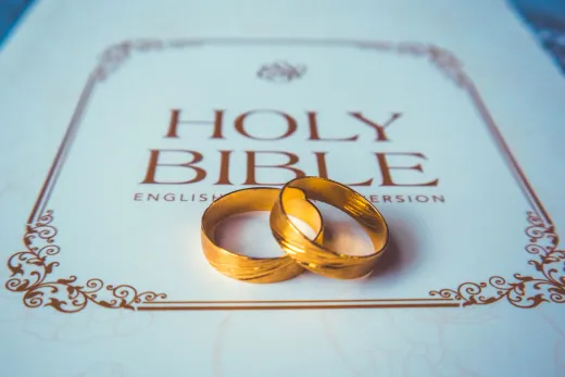 Two golden wedding rings placed on a holy bi - Competitor Platforms