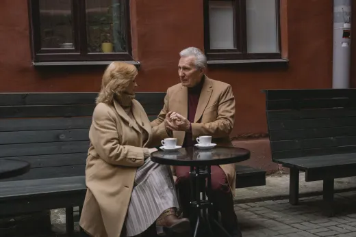 An elderly couple enjoys a conversation over - Dating & Apps