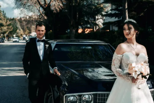 Bride and groom posing with classic car on a - Marriage & Relationships