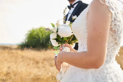 Bride and groom in elegant attire holding a - Marriage & Relationships