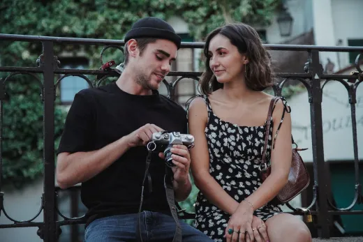 Couple sitting on a bench enjoying a camera - Marriage & Relationships