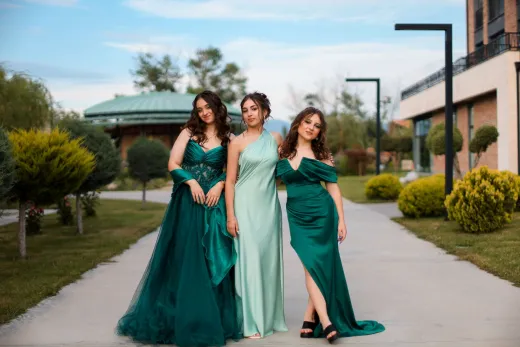 Three women in elegant green dresses standin - Wedding Fashion & Jewellery