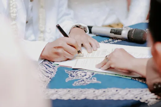 Close up of hands signing wedding documents - Weddings (General)